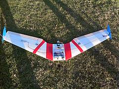 Das Bild zeigt den FPV Wing, ein Nurflügel Modell auf dem Boden liegend von vorne oben.
